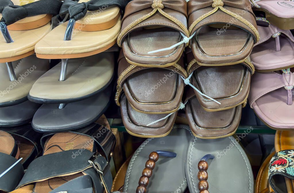 Selection of handmade leather sandals and beaded slides on a display table